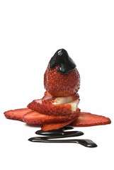 Fresa con chocolate sobre láminas de fresa.