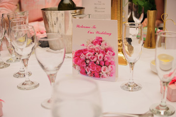 Wedding dinner table with menu and glasses.