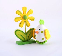 Easter simbol yellow wooden flower and white egg as chicken toy