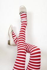 head over heels. female legs in stripy stockings;