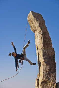Female rock climber falling.