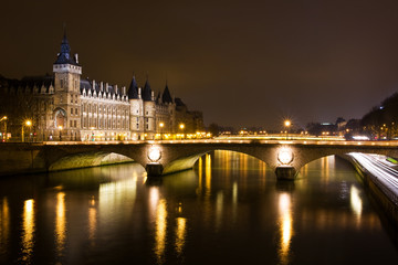 La Conciergerie and Pont au Change, over the Seine river at nigh