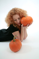 curly red haired girl with pumpkins isolated on white