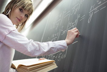 pretty college student/young teacher in front of a chalkboard © lightpoet