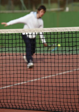 Tennis player in action (selective focus, focus on the net).