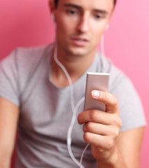 Young handsome man listening to the music on his portable mp3 p