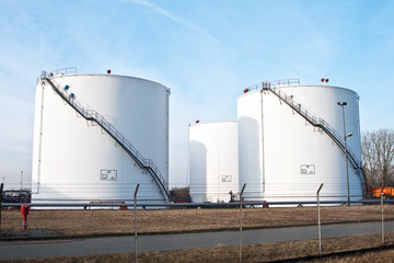 white tanks in tank farm with blue sky