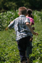 Two child are running in the garden