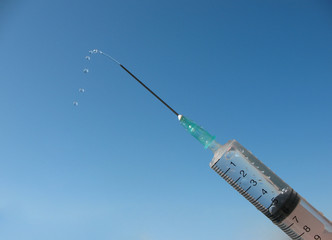 Disposable syringe against the blue sky