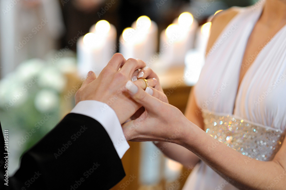 Poster bride putting a ring on groom's finger