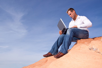 Man with laptop telecommuting outdoors