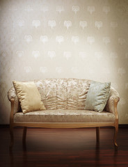 Luxury gold glamorous sofa in the background of vintage wallpape