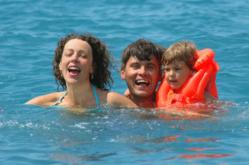 Happy family with little child in water