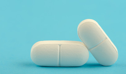 Two white tablet on a blue background.