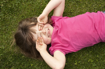 little girl laying in grass