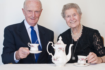 Dignified couple in eighties enjoying a cup of tea