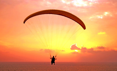 Flug des Paraplanes über dem Mittelmeer bei Sonnenuntergang
