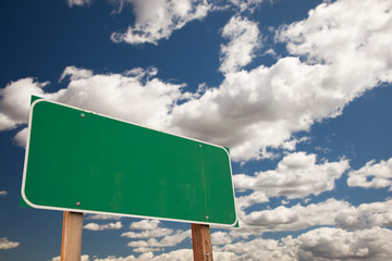 Blank Green Road Sign Over Clouds with Text Room
