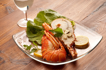 sliced lobster with lettuce lemon and glass of wine
