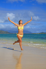 Fototapeta na wymiar teenage girl runs along the beach at lanikai, hawaii