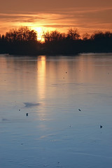 Sonnenuntergang im Winter über einem Eissee