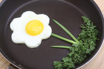 Flower shaped fried egg with greenery