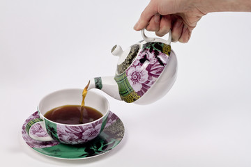 Pouring tea using decorated tea set - 21214741