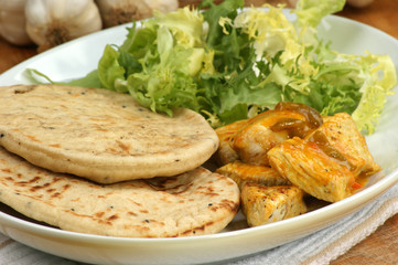 Naan bread und Curryhuhn auf einem Teller