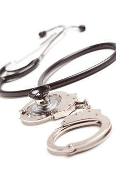 Stethoscope and Handcuffs on White