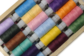 Sew threads in the wood box isolated on white