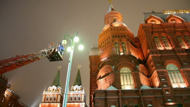 mounter changing workless street lamp on moscow night street