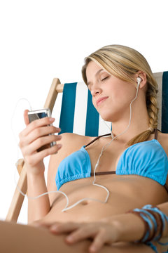 Beach - Happy woman relax on deck chair with music