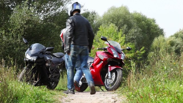 Two bikers on their motorcycles start on footpath together