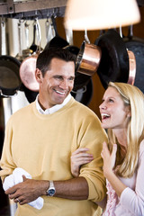 Close father and teen daughter laughing in kitchen