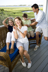 Smiling family sitting and laughing together outdoors on terrace