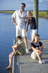 Family with two teenage children on dock by water