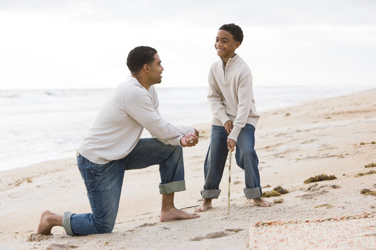 African-American Father And Ten Year Old Son Playing On Beach