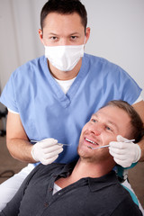 Handsome young man visiting dentist for dental checkup