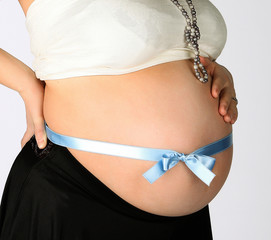 pregnant girl with a blue ribbon tied on the stomach