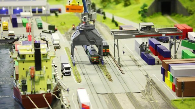 in modern toy city train on rail near transport ship
