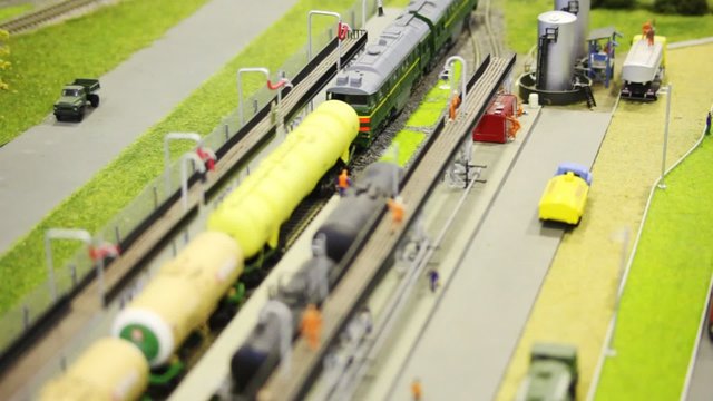 in toy fuel station train pushes tank wagon on rail