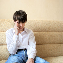 sad teenager sitting on the sofa