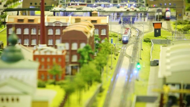 in small model city trian goes near to factory and church