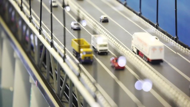 toy tiny automobile cars, trucks, train stand on bridge
