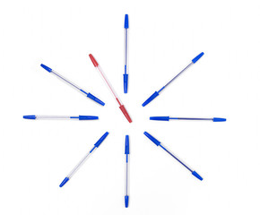 Clock set on white background by pens