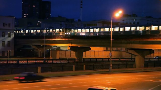 traffic of cars and light rail train in night street of Moscow