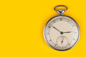 old clock isolated on a yellow background