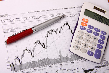 Naklejka na ściany i meble White calculator and a red pen on a financial chart