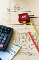 Bauplan mit Rechner, Stift, Maßstab und Geld