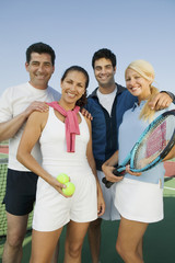 four mixed doubles tennis players by net at tennis court portrait